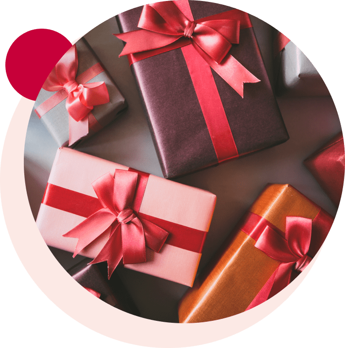 Several gift boxes with shiny red ribbons are arranged on a surface.