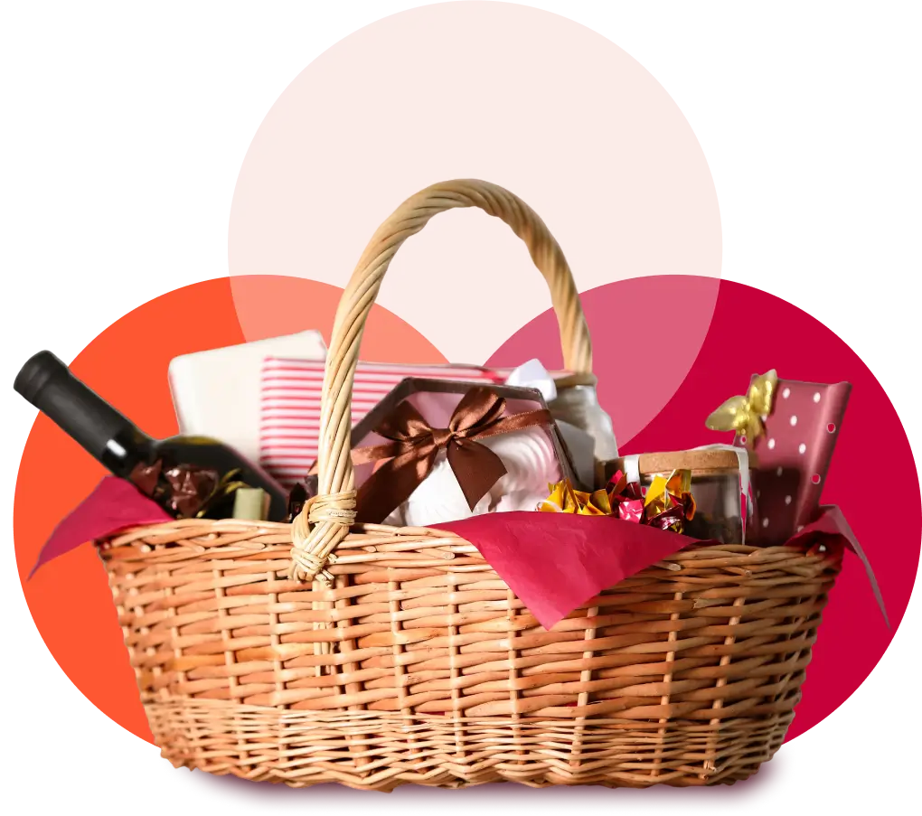 A woven basket filled with a bottle of wine, wrapped gifts, and assorted treats, set against a background with overlapping pink and red circles.